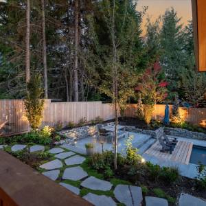 Whistler backyard landscape with custom pool, stone patio and planting by Terracraft