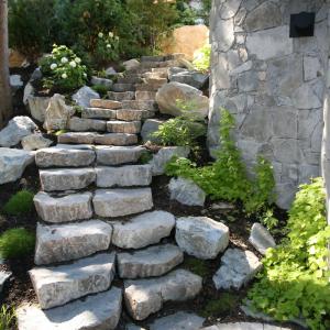 Stone retaining walls with integrated garden stairs up a slope