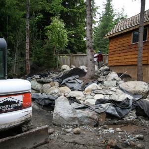 Excavation equipment preparing a Squamish site for landscaping and walls