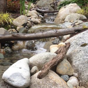 Squamish backyard with winding rock stream and cascading water