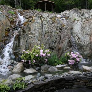Natural stone water feature with dual waterfalls spilling into a pool