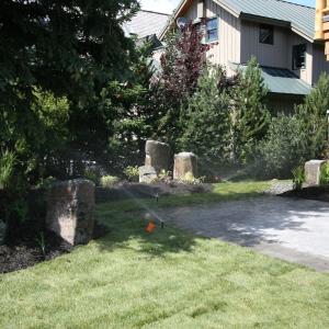 Whistler front entrance landscape with irrigation sprinklers watering lawn and planting beds