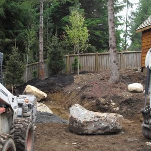 Excavator shaping grades and levels during a landscape project