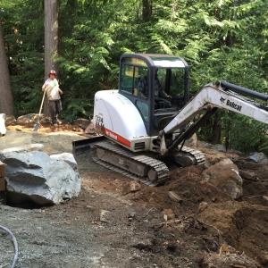 Backyard excavation creating space for new patio and retaining walls